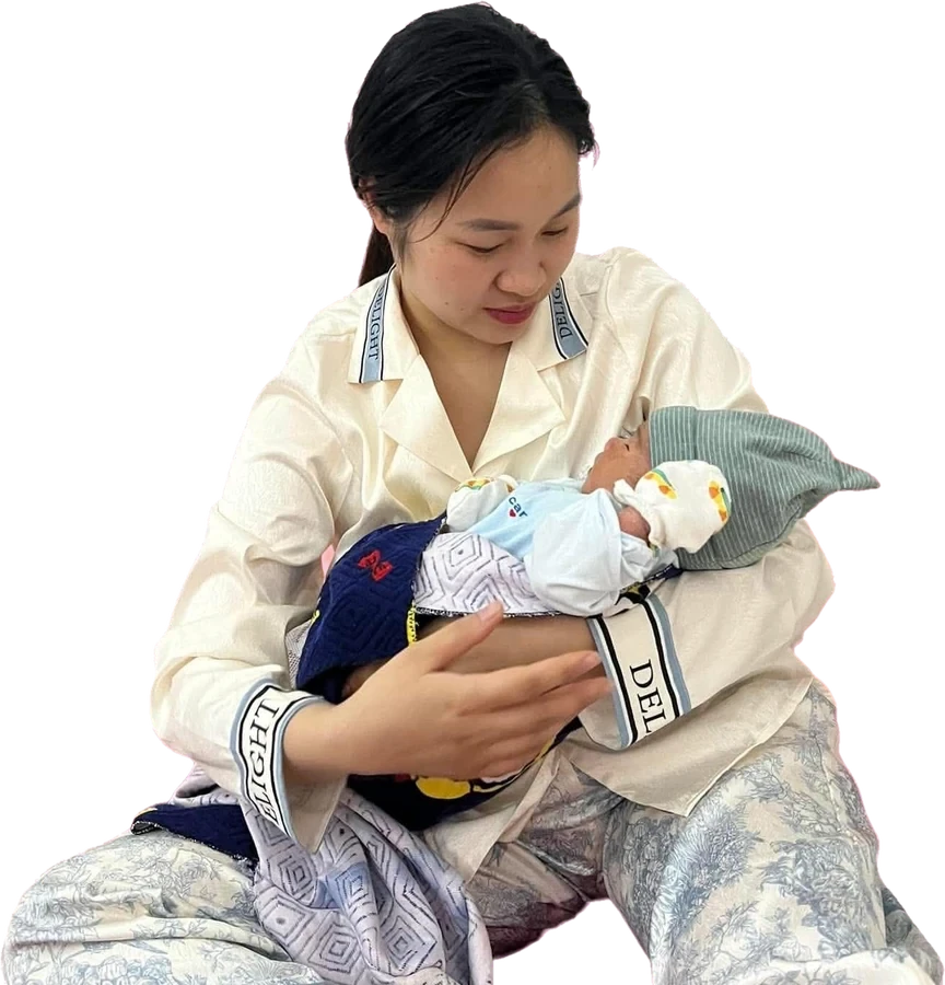 一位母亲抱着裹在襁褓中的新生儿
